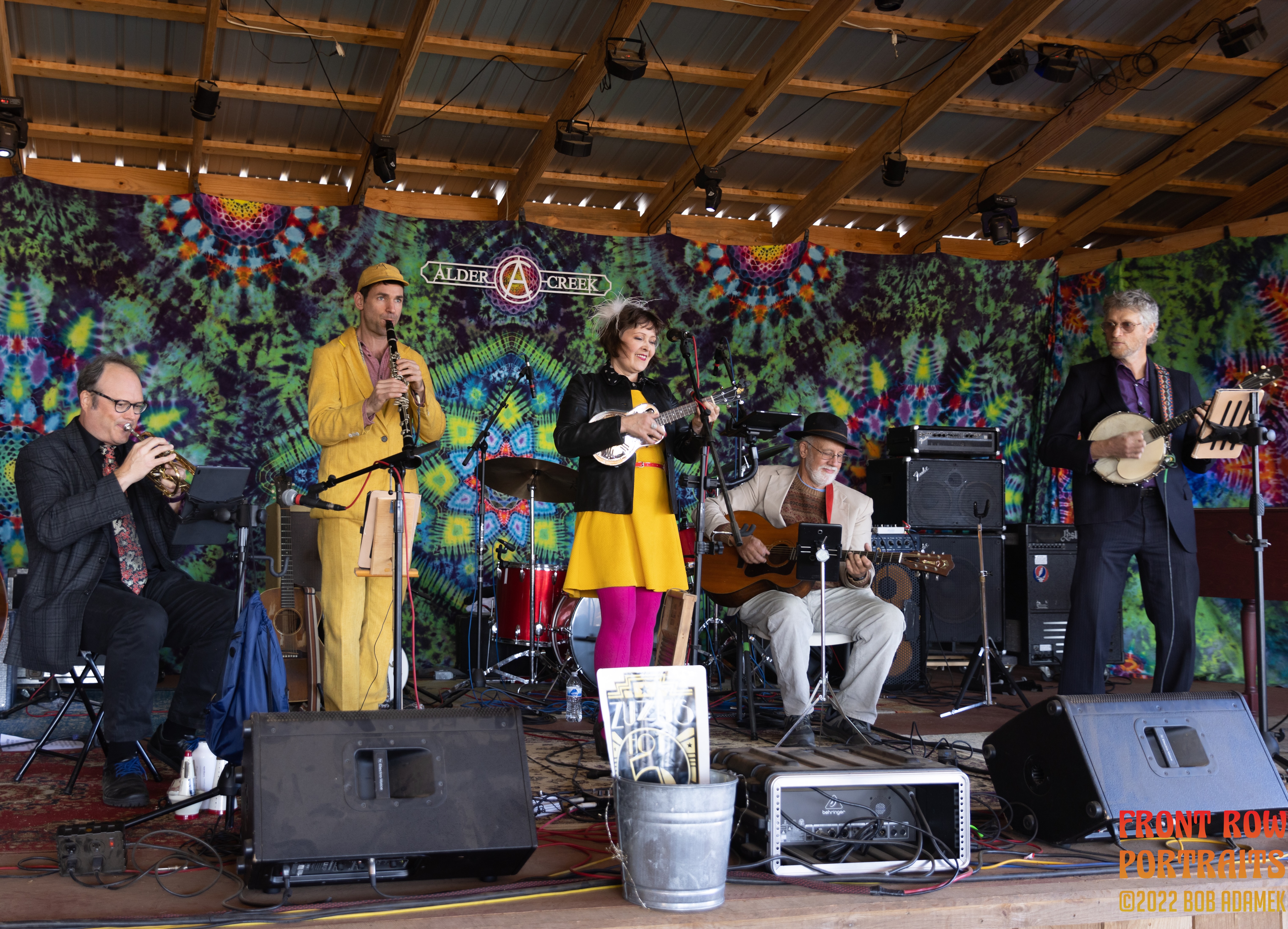 Zuzu's Hot Five on stage in front of a tie-dyed background